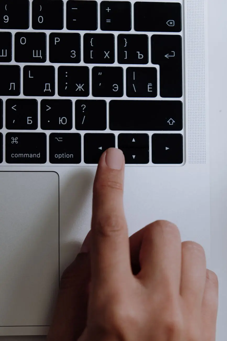 Mano escribiendo en el teclado de una computadora portátil