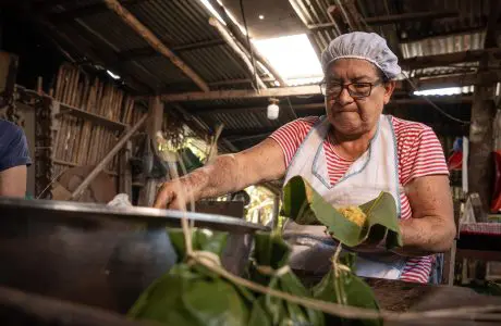Preparación de comida tradicional envuelta en hojas