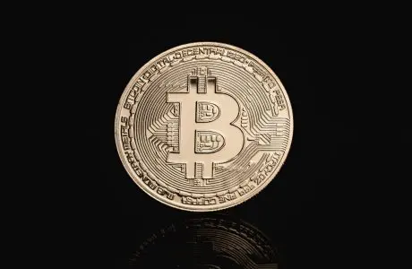 Representación física decorativa de Bitcoin sobre fondo oscuro