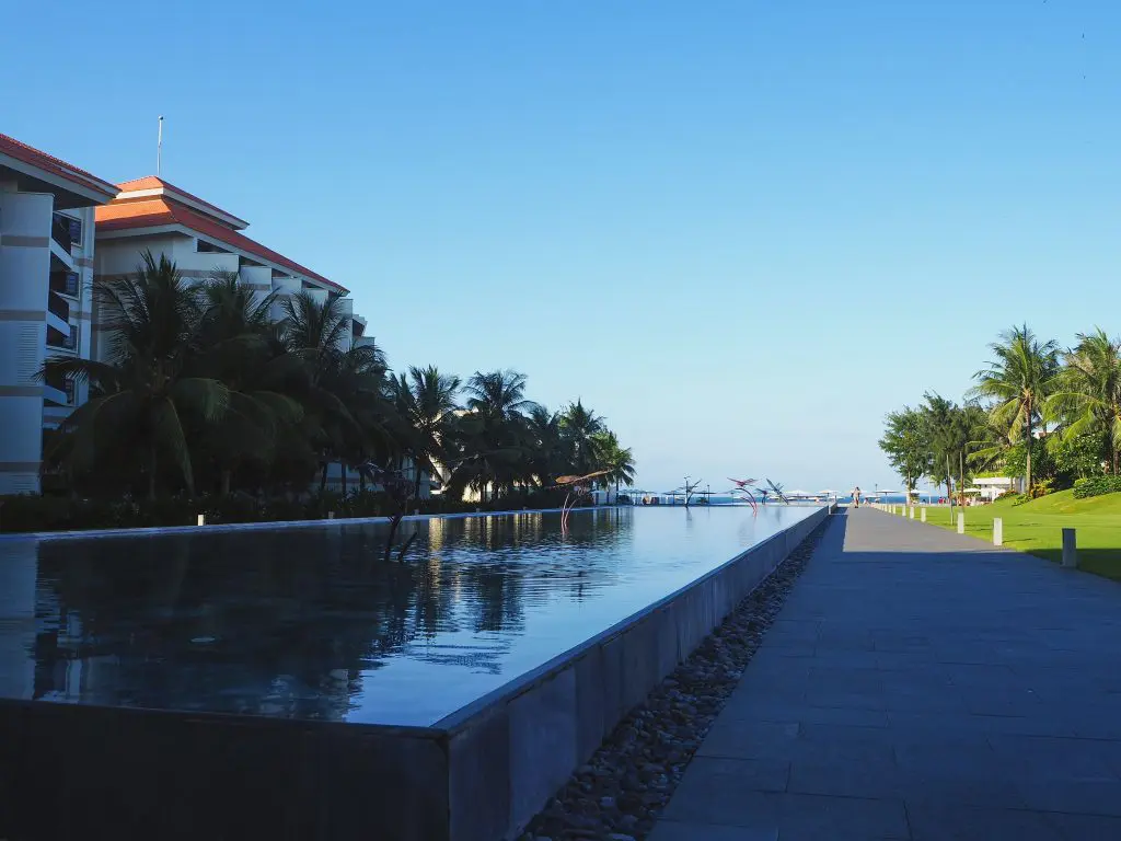 Hotel tropical con piscina exterior y palmeras