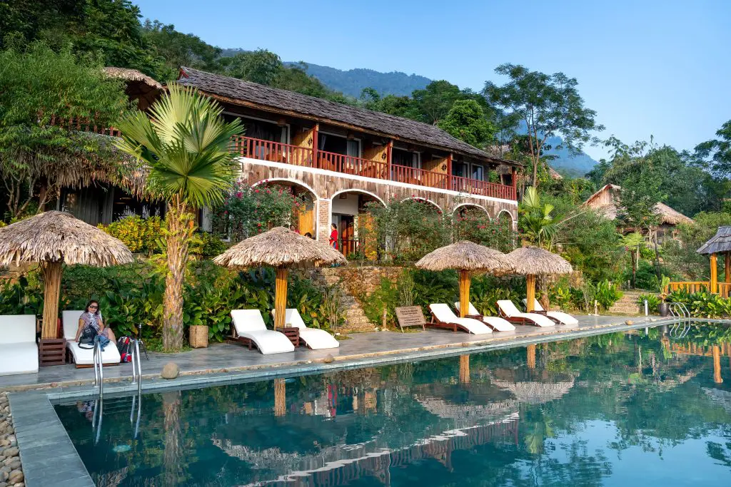 Hotel tropical con piscina y vegetación