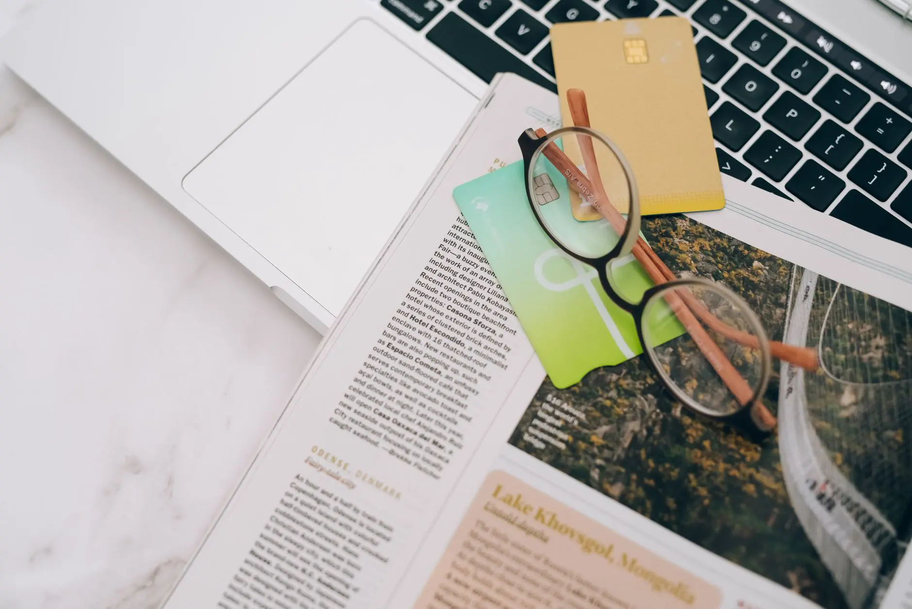 Gafas y tarjetas bancarias junto a una computadora