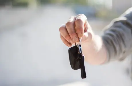 Mano entregando una llave de automóvil