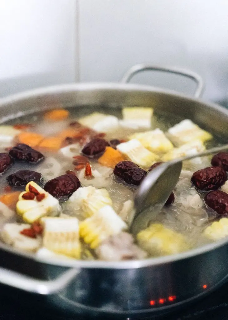 Caldo con maíz y vegetales cocinándose en una olla