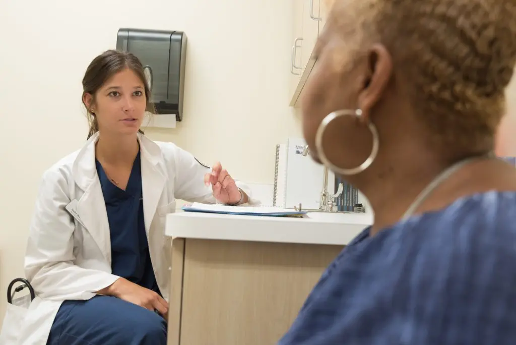 Profesional de salud conversando con una paciente durante un chequeo