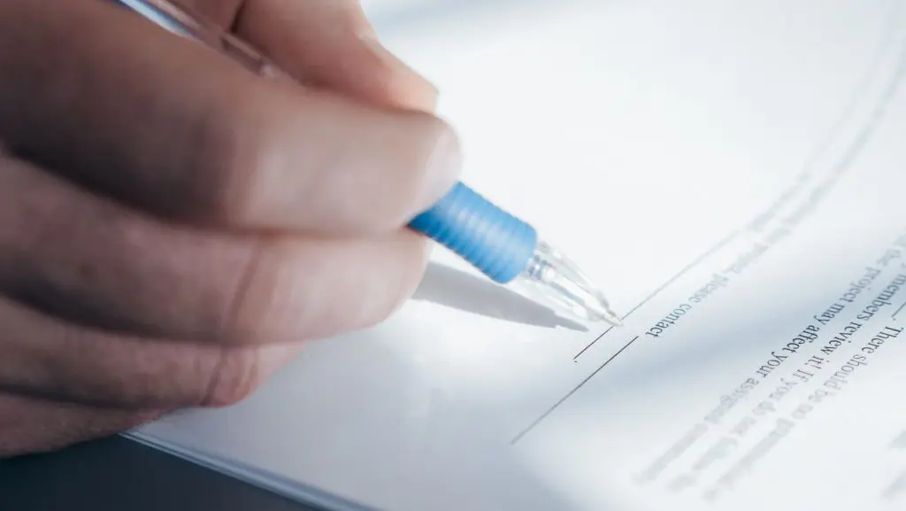 Persona firmando documentos legales