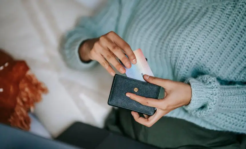 Persona sacando una tarjeta bancaria de su cartera