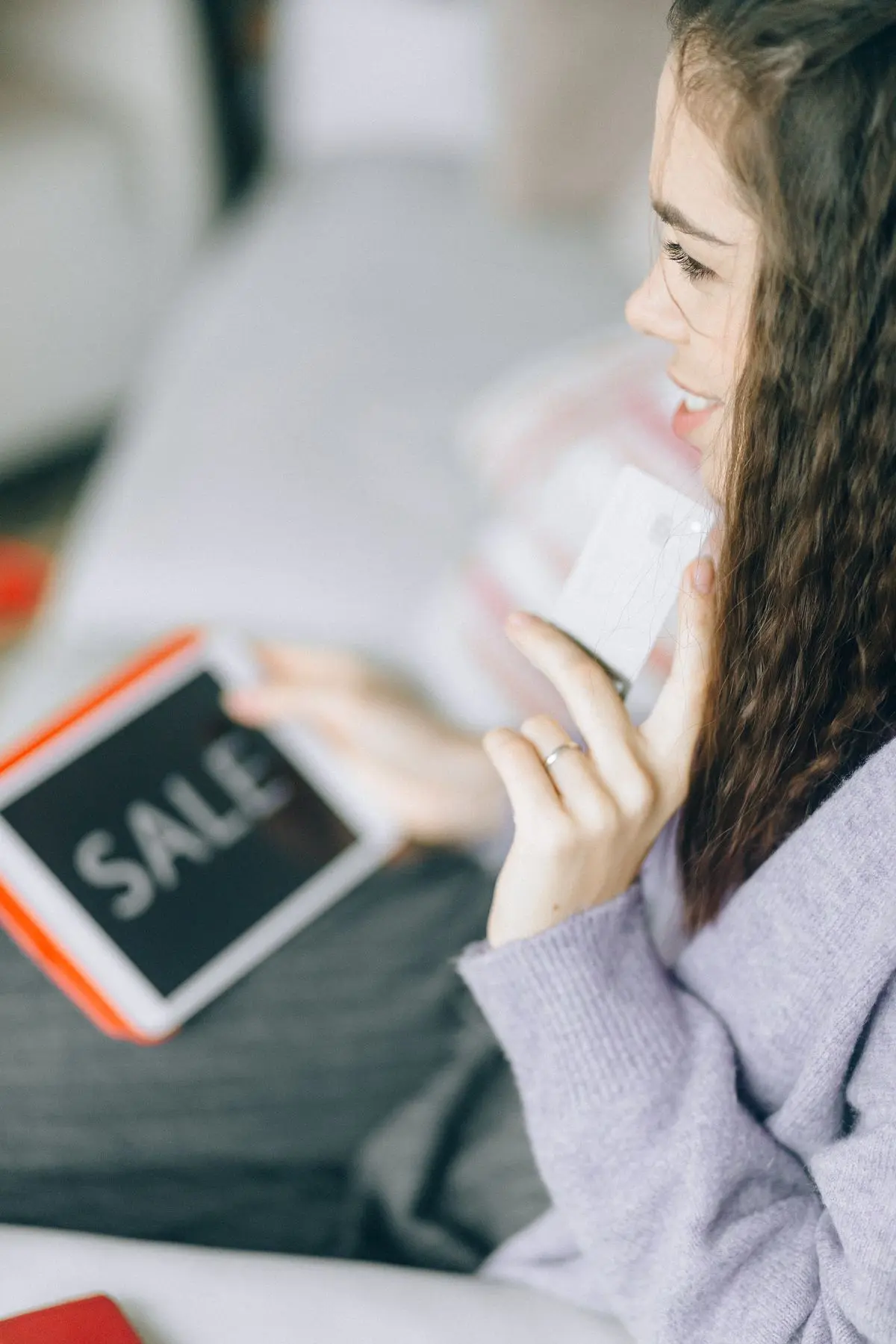 Manos con una tarjeta y una tableta al consultar una compra por internet