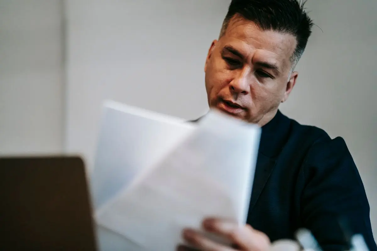 Persona revisando documentos impresos en su escritorio