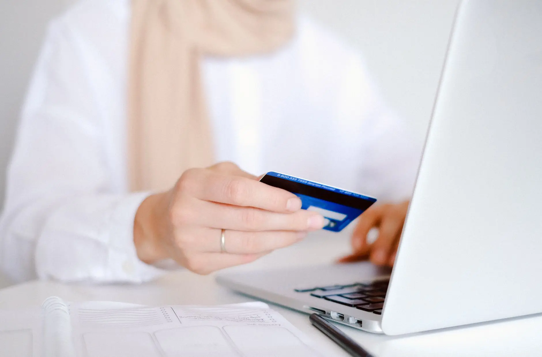 Persona usando una tarjeta de crédito y una computadora portátil
