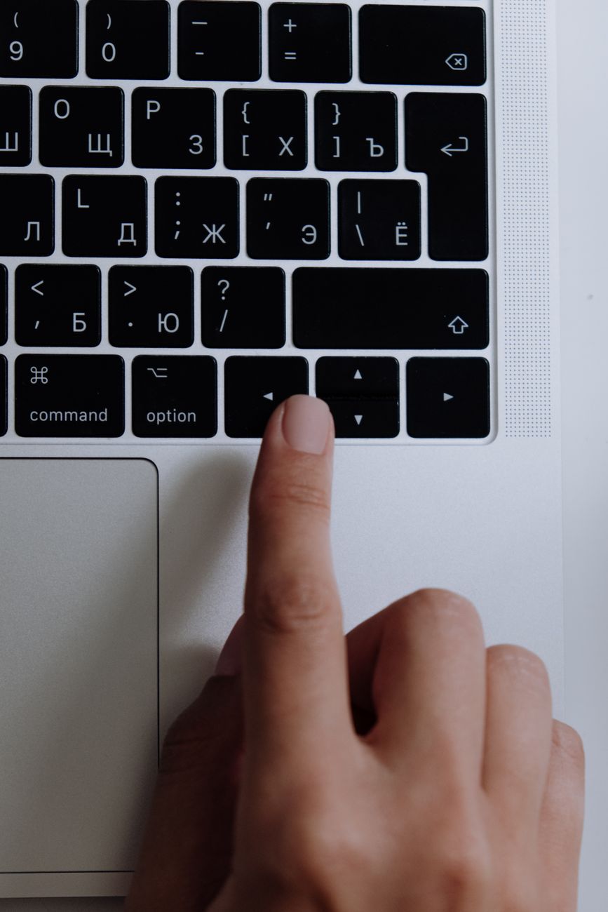 Mano escribiendo en el teclado de una computadora portátil