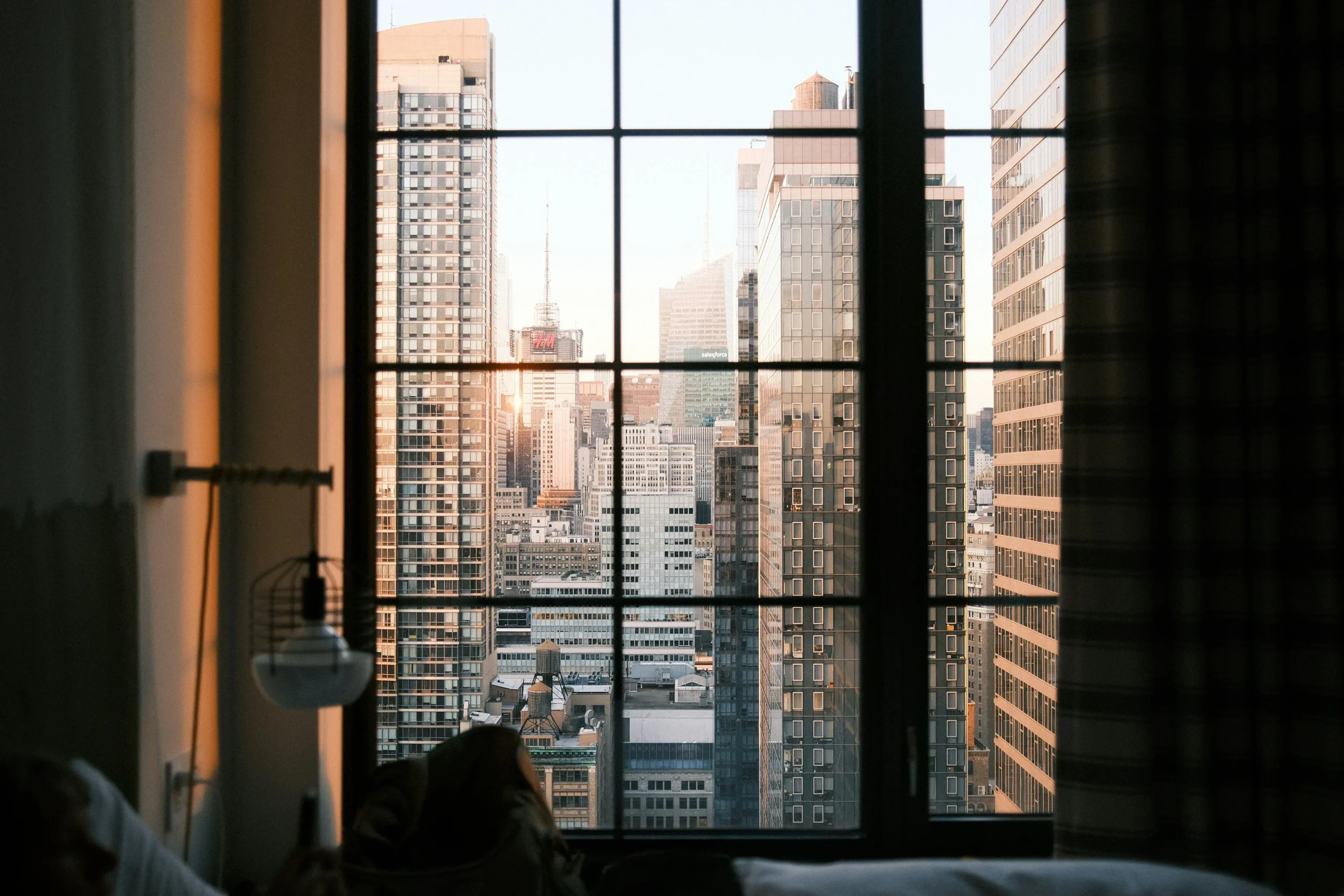 Foto por <a href="https://unsplash.com/@snowbot?utm_source=unsplash&utm_medium=referral&utm_content=creditCopyText">Kevin Snow</a> on <a href="https://unsplash.com/photos/a-view-of-a-city-from-a-bedroom-window-Pvyue6LixGY?utm_source=unsplash&utm_medium=referral&utm_content=creditCopyText">Unsplash</a>