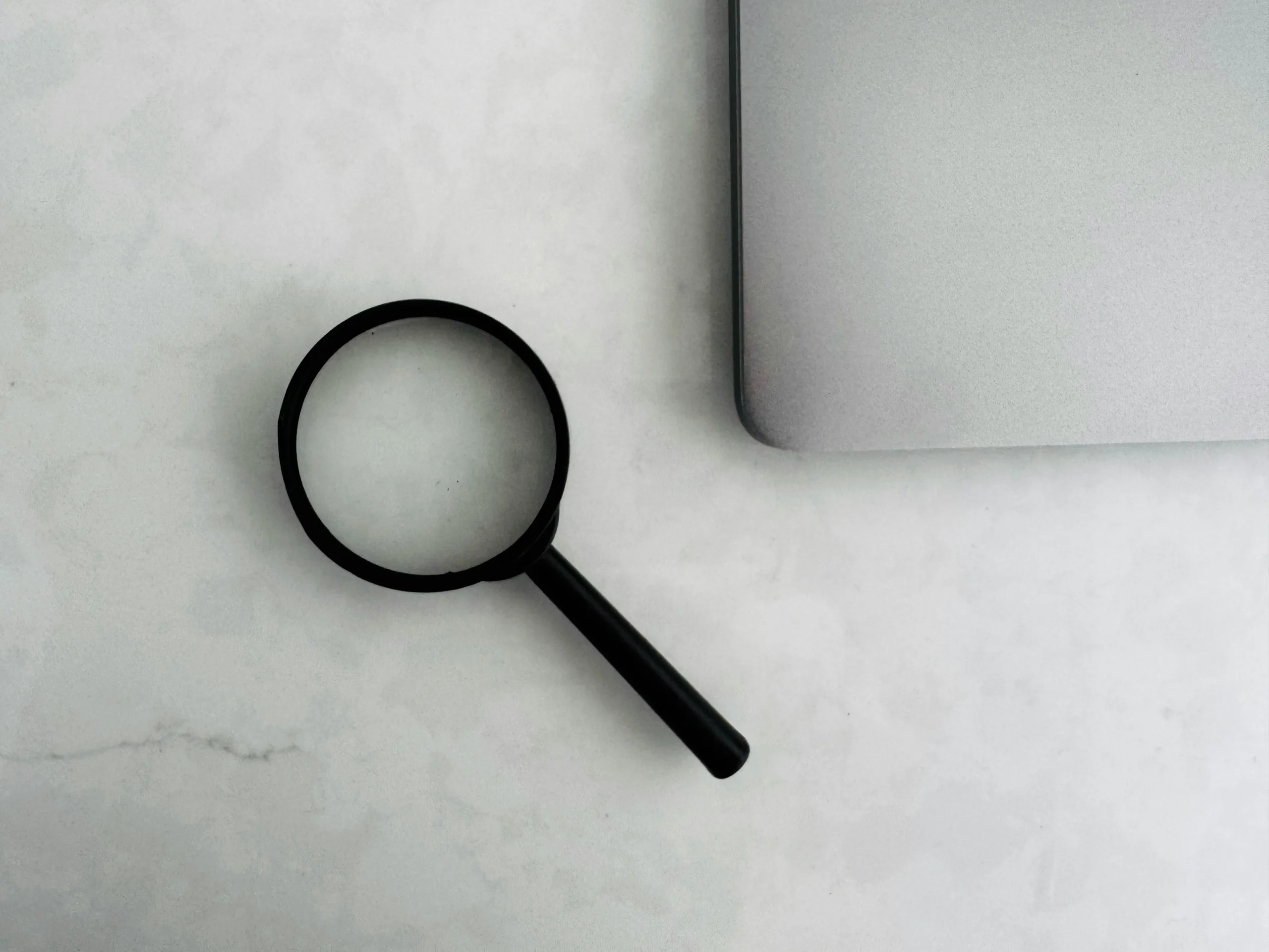 Foto por <a href="https://unsplash.com/@duforddigital?utm_source=unsplash&utm_medium=referral&utm_content=creditCopyText">MJ Duford</a> on <a href="https://unsplash.com/photos/magnifying-glass-sits-near-a-laptop-on-a-table-P_5mirRrg0k?utm_source=unsplash&utm_medium=referral&utm_content=creditCopyText">Unsplash</a>
