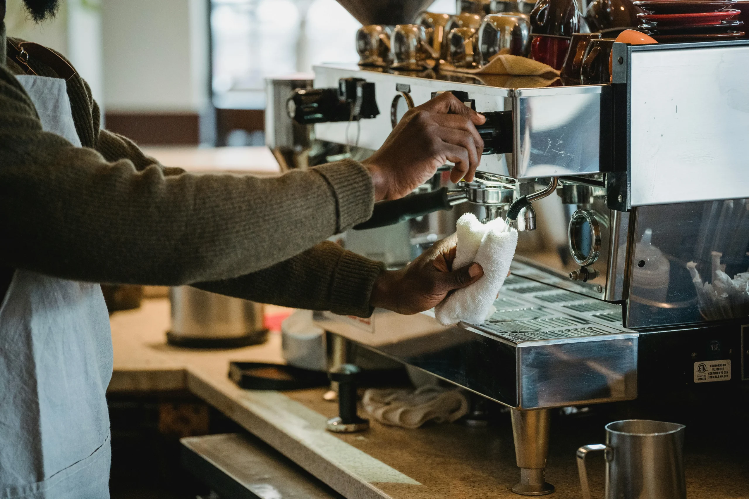 <a href="https://www.pexels.com/es-es/foto/hombre-trabajando-cafeteria-maquina-de-cafe-13735915/" target="_blank">Foto de Mizuno K</a>
