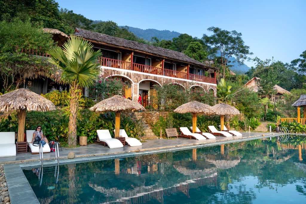 Hotel tropical con piscina y vegetación