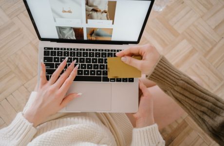 Persona usando una computadora portátil junto a una tarjeta bancaria
