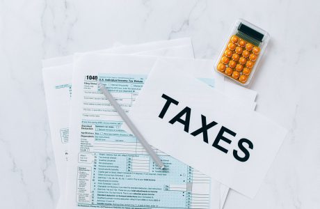Calculadora y documentos fiscales de archivo junto a la palabra TAXES