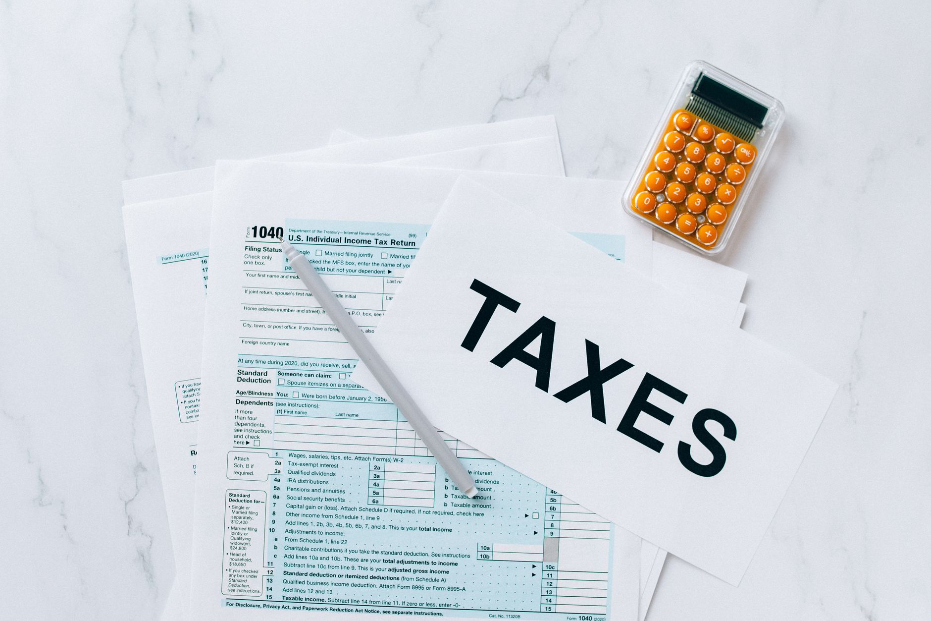 Calculadora y documentos fiscales de archivo junto a la palabra TAXES