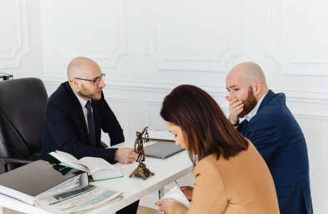 Tres personas revisando documentos durante una consulta profesional