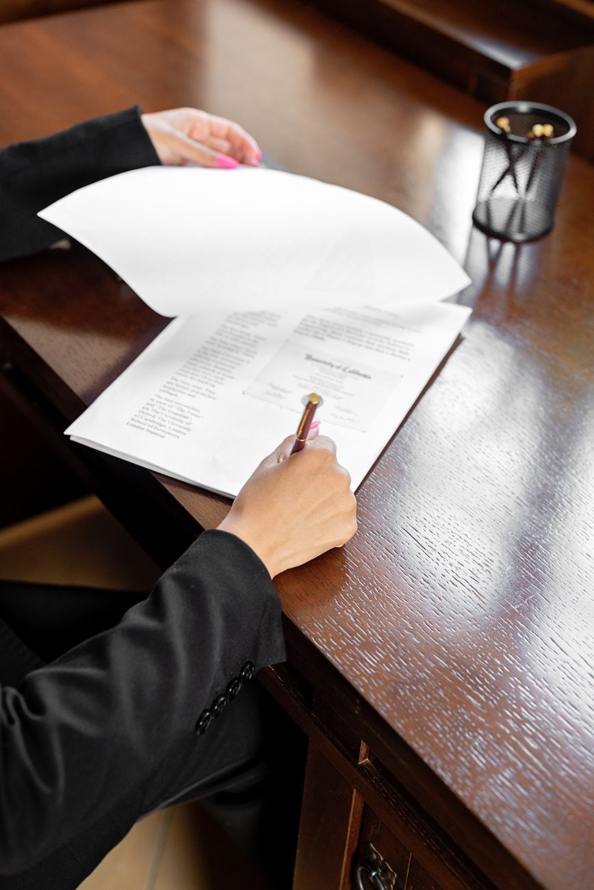 Persona firmando un documento sobre una mesa