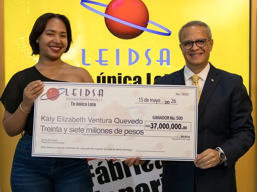 Katy Elizabeth Ventura Quevedo sosteniendo el premio de la loteria junto a presentador de programa