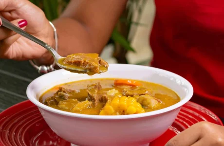 Sancocho dominicano servido con víveres y carne