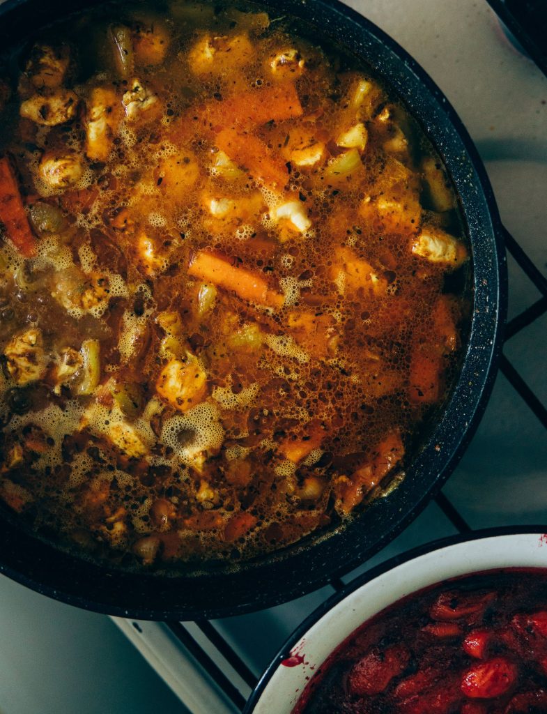 Vegetales y víveres cocinándose en una olla de sopa