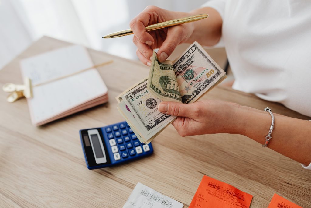 Persona contando dinero con una calculadora