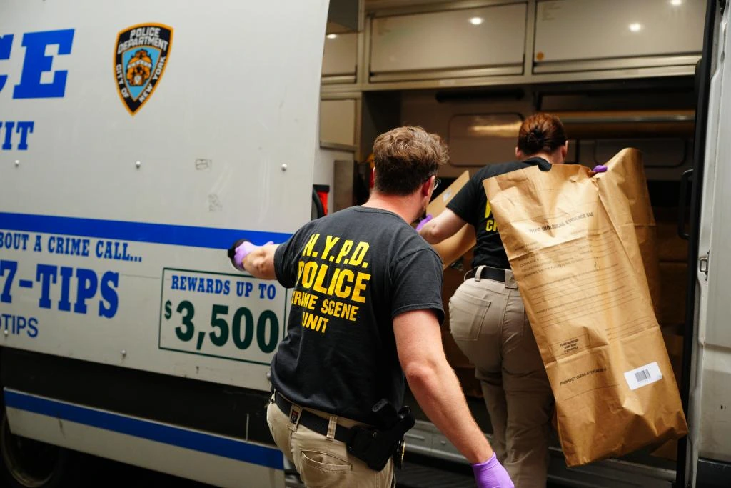 Miembros de la Unidad de Investigación de la Escena del suceso del Departamento de Policía de Nueva York recogen pruebas en el lugar de los hechos, en el número 126 de la calle Ludlow, en el Lower East Side.