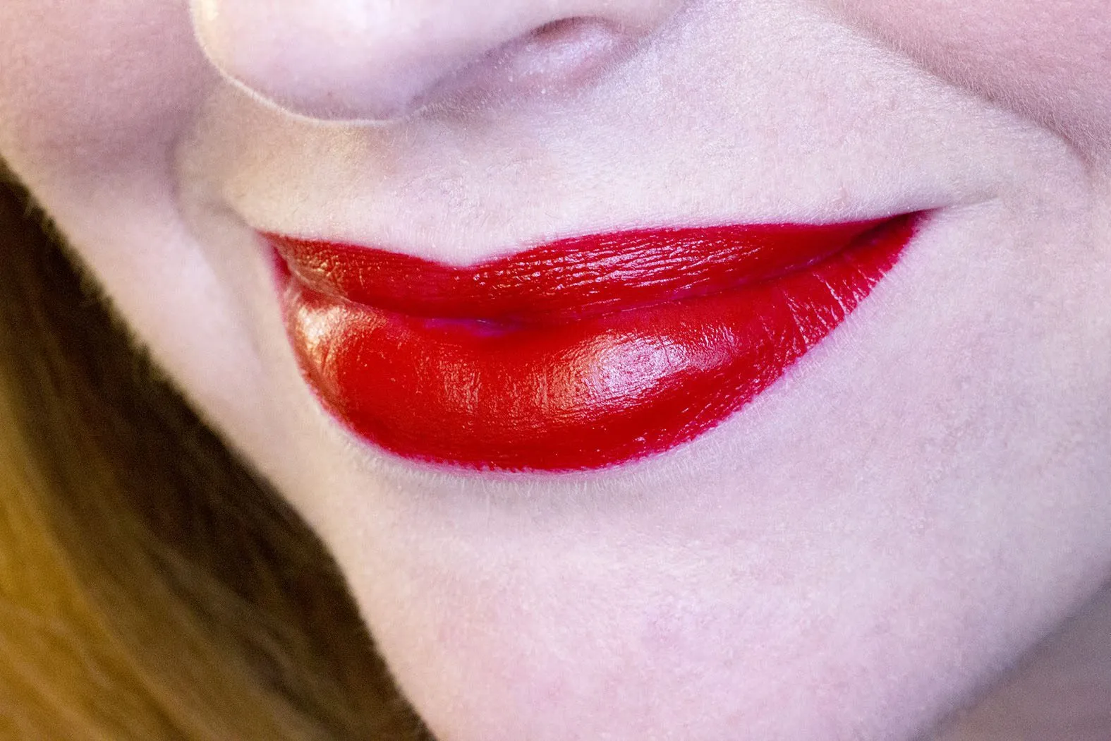 Img. referencial de una mujer utilizando un labial rojo