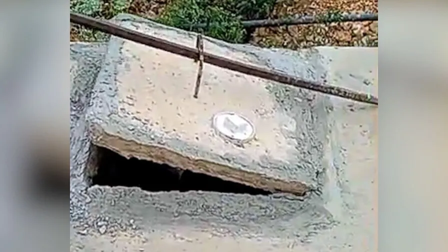 Imagen del momento en que destapan el pozo séptico donde fue encontrado los restos de Héctor Bienvenido Cedeño Ávila. (FOTO DE PANTALLA DE VIDEO.)
