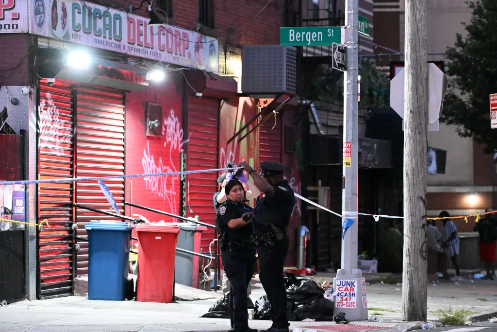Miembros de la unidad de investigación de la escena del crimen del Departamento de Policía de Nueva York trabajan en el lugar de un incidente con proyectiles el domingo 16 de agosto de 2026 en Brooklyn, Nueva York.