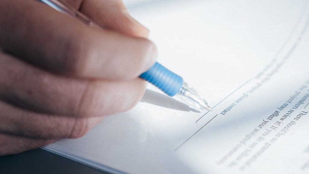 Persona firmando documentos legales