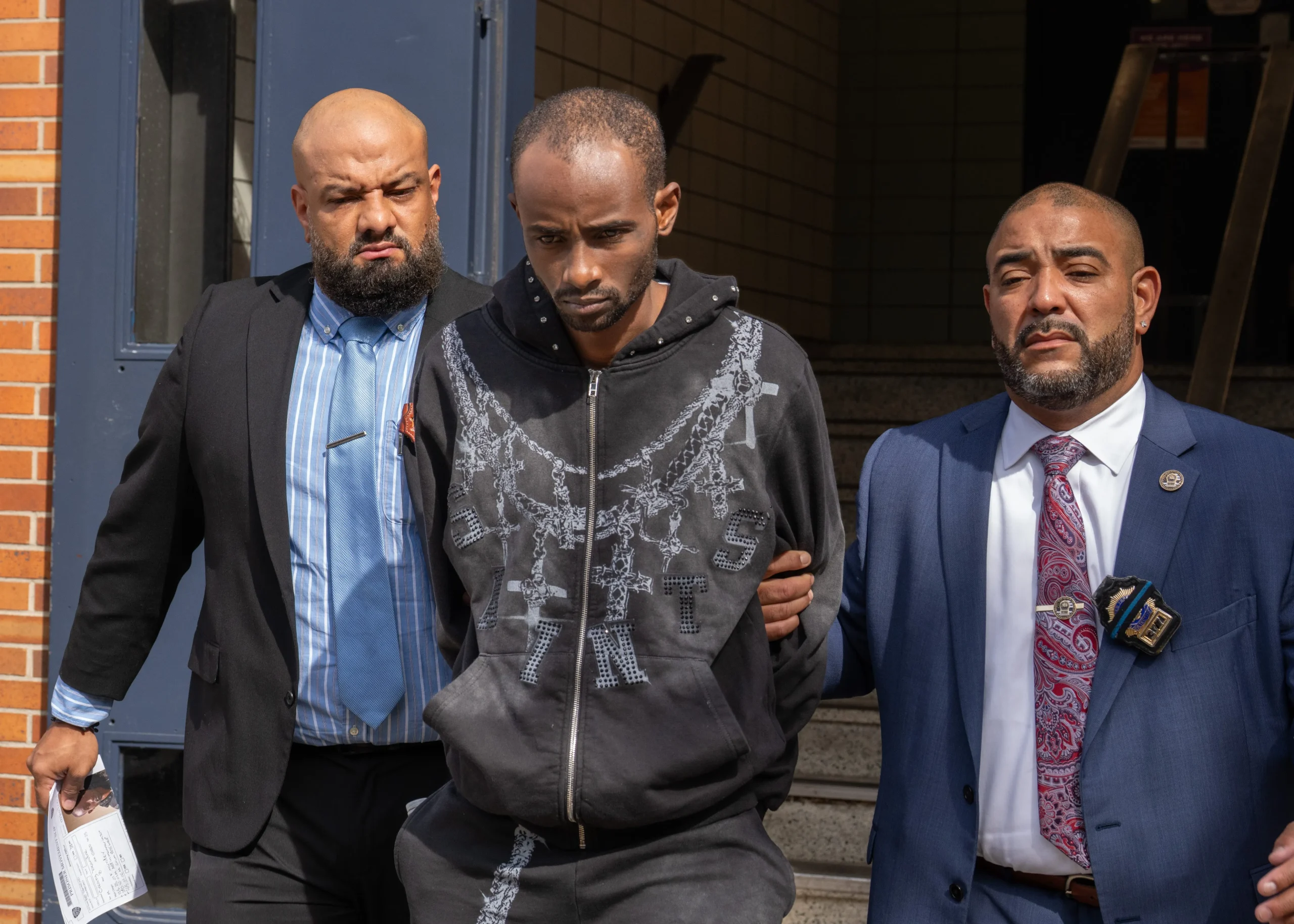 Deandre Creary aparece bajo custodia policial al salir de la comisaría del Precinto 77 del NYPD en Brooklyn, el martes 8 de septiembre de 2026. (Barry Williams/ New York Daily News)