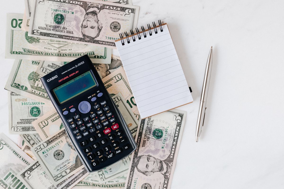 Calculadora, libreta y dólares para revisar un presupuesto