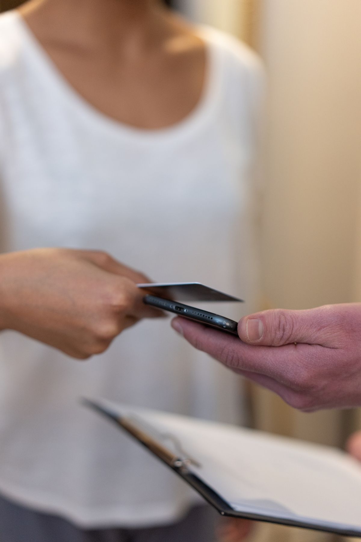 Persona entregando una tarjeta bancaria al realizar un pago