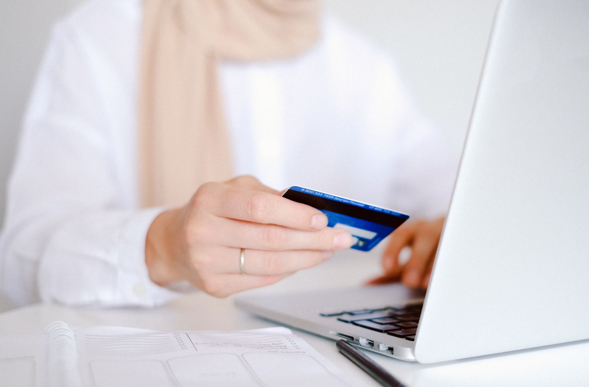 Persona usando una tarjeta de crédito y una computadora portátil