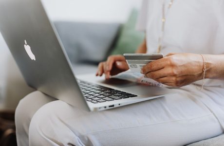 Persona con una tarjeta bancaria usando una computadora en casa