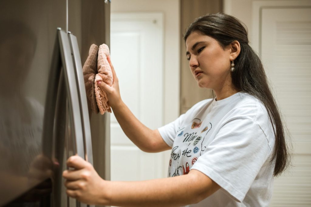 Persona limpiando el interior de un refrigerador