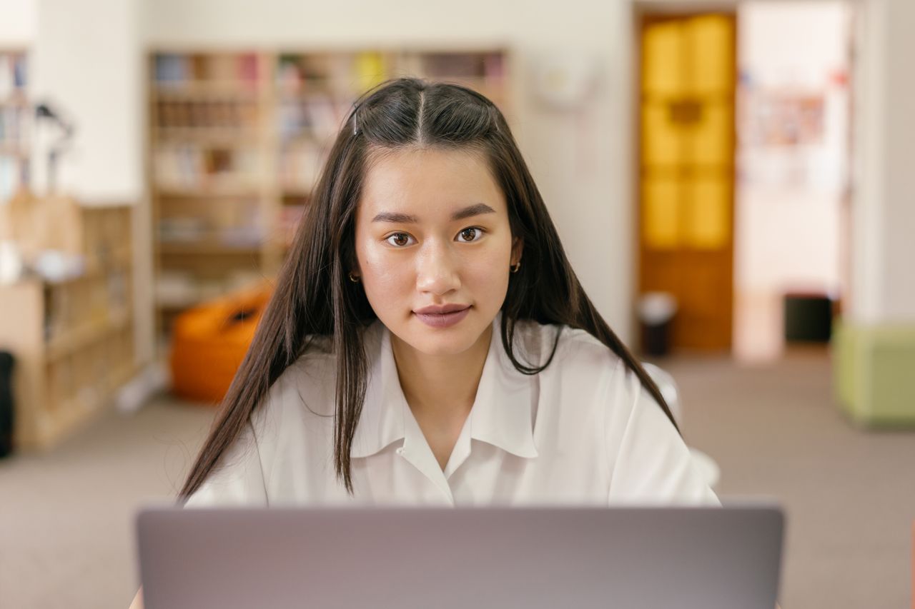 Mujer consultando una computadora en una biblioteca